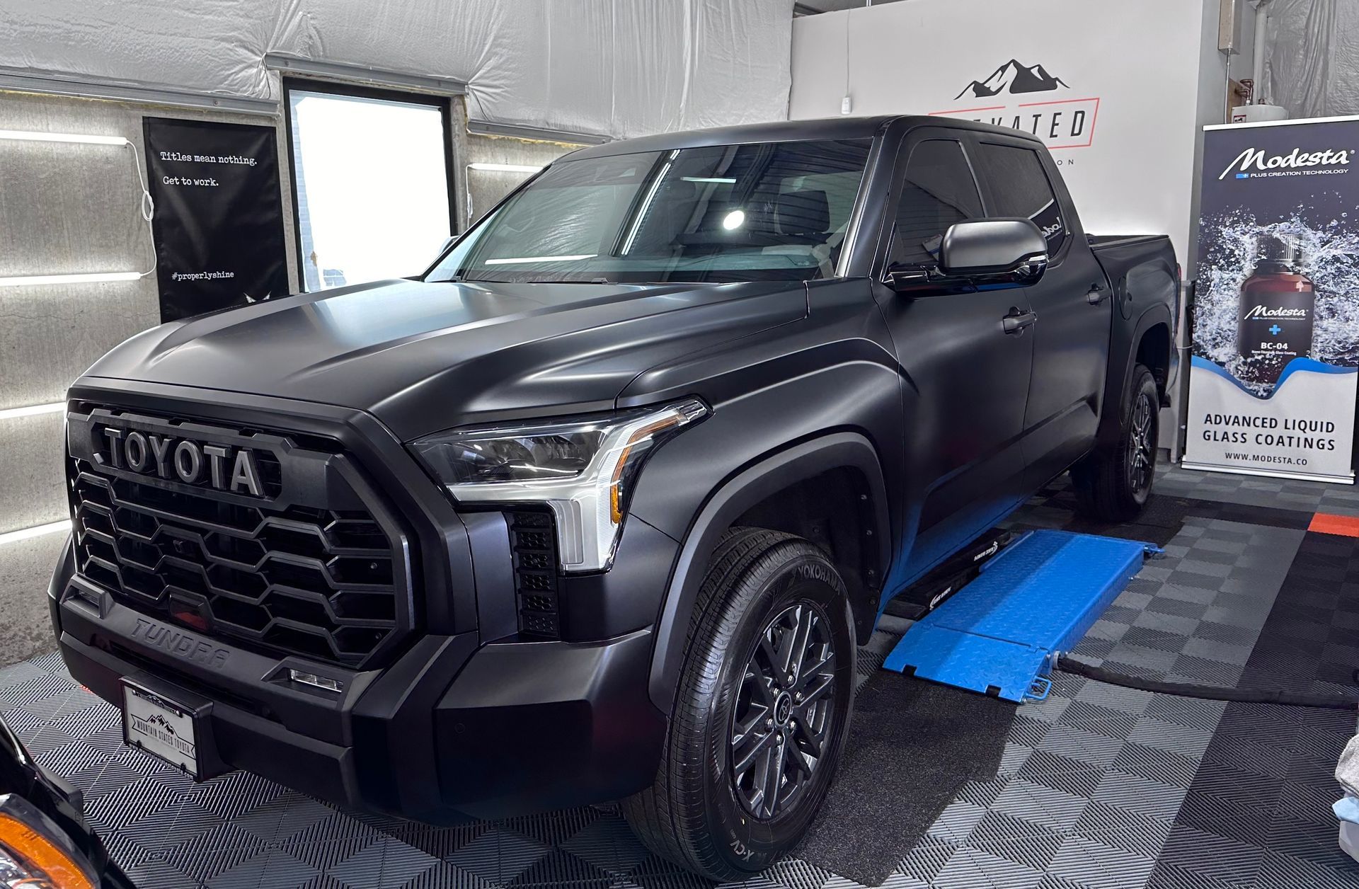 A black toyota tundra is parked in a garage.