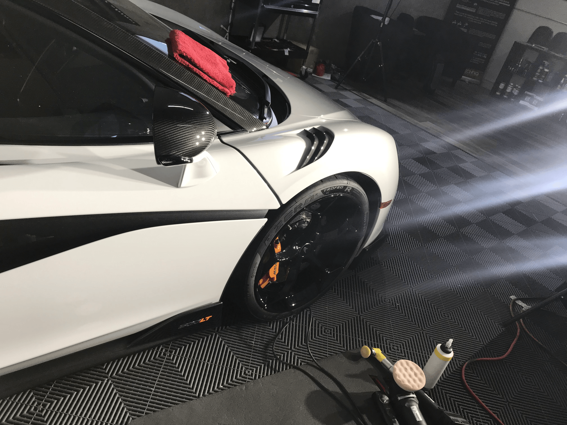 A white sports car is parked in a garage