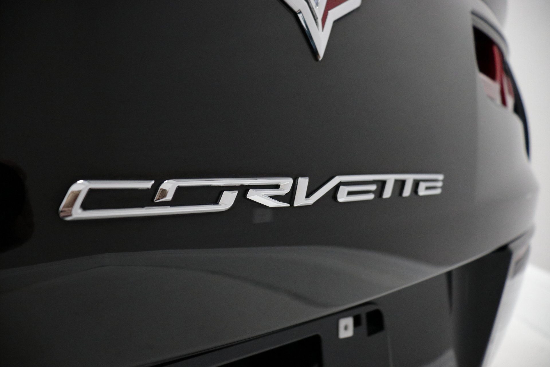 The back of a black corvette with the word corvette on it.