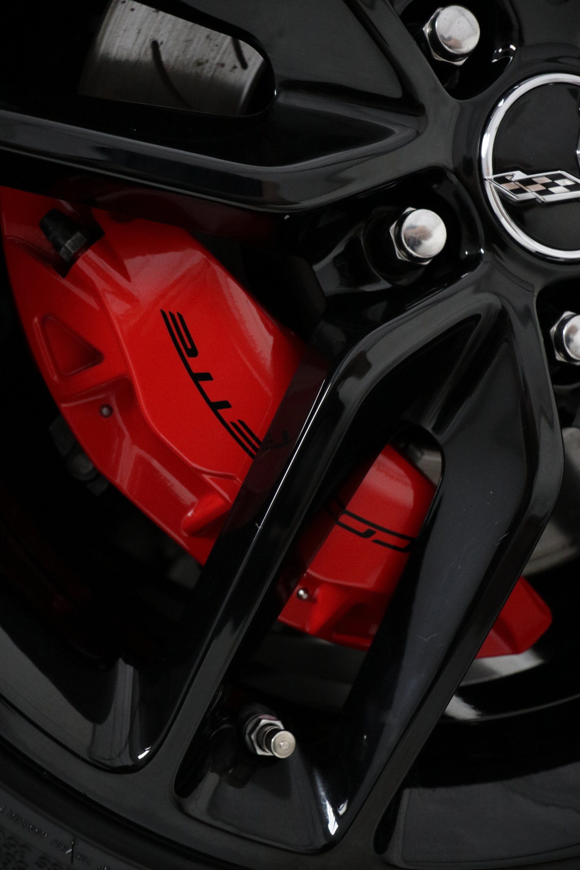 A close up of a red brake caliper on a black wheel