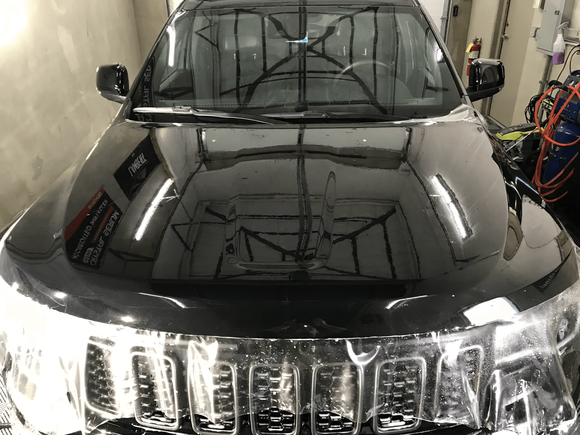 A black jeep grand cherokee is parked in a garage.