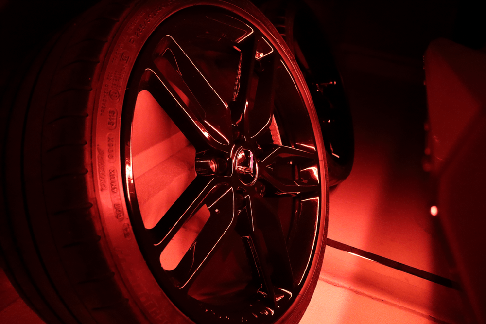 A close up of a car wheel with red lights on it