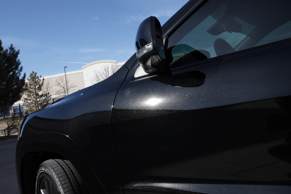 A black car is parked in front of a building