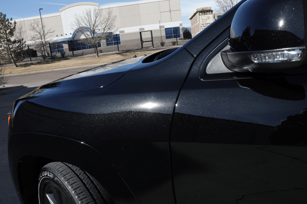 A black car is parked in front of a building