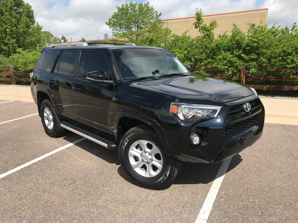 A black toyota 4runner is parked in a parking lot.