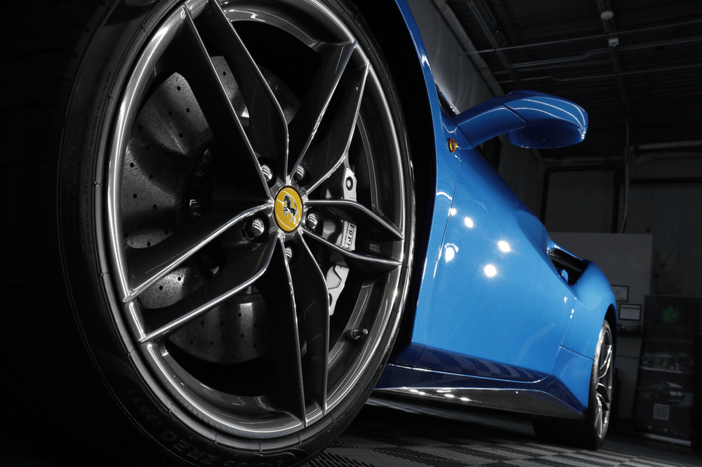 A close up of a blue sports car 's wheel