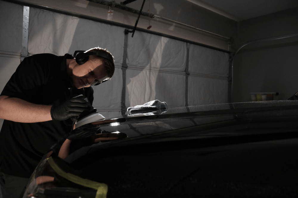 A man is working on a car in a garage.