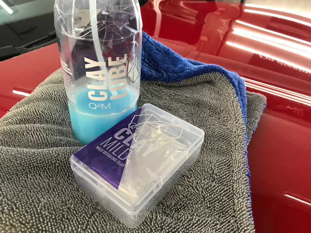 A bottle of clay cube is sitting on a towel next to a box.