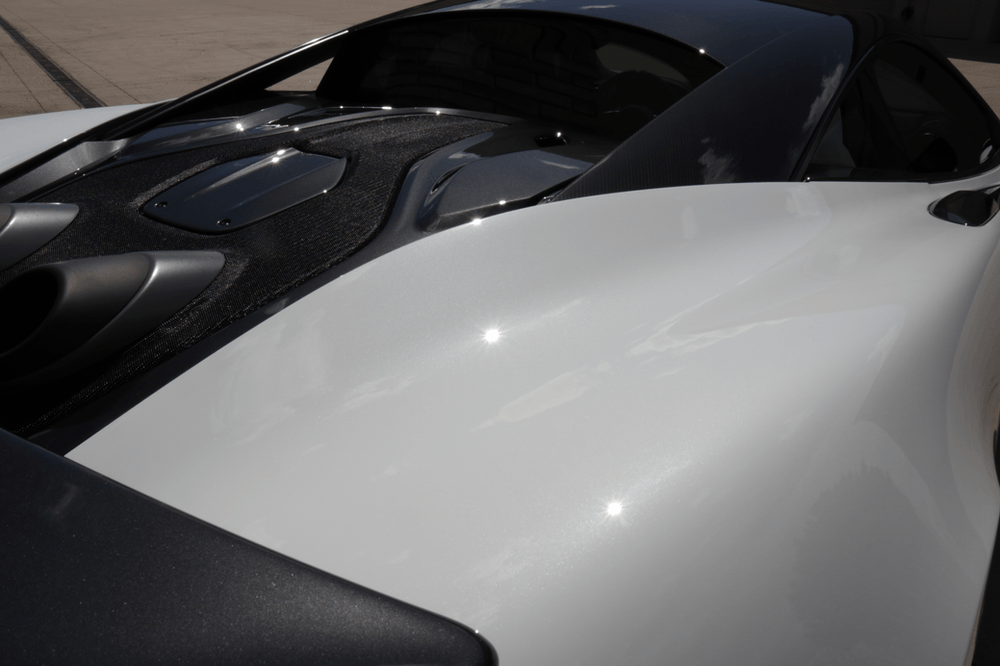 A close up of the hood of a white sports car