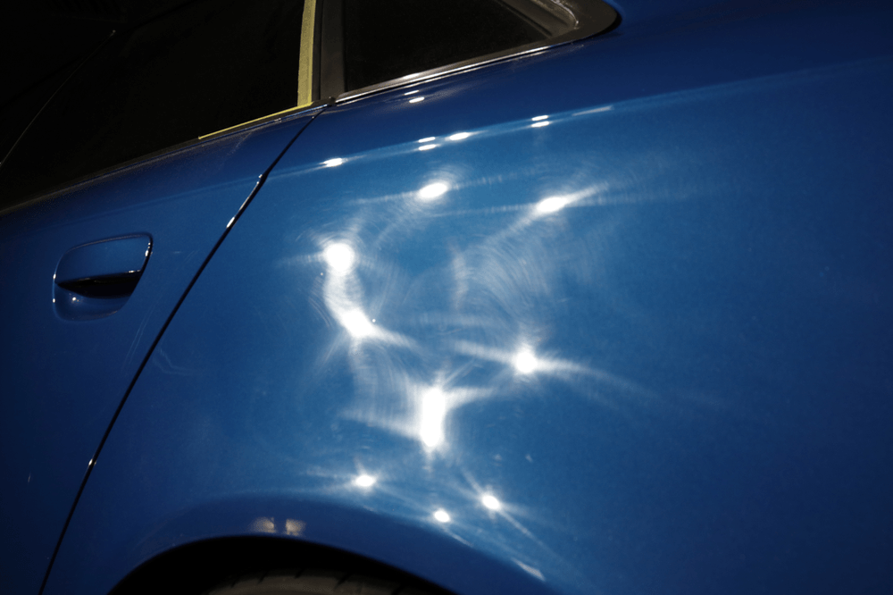 A close up of a blue car with a lot of sparkles on it.
