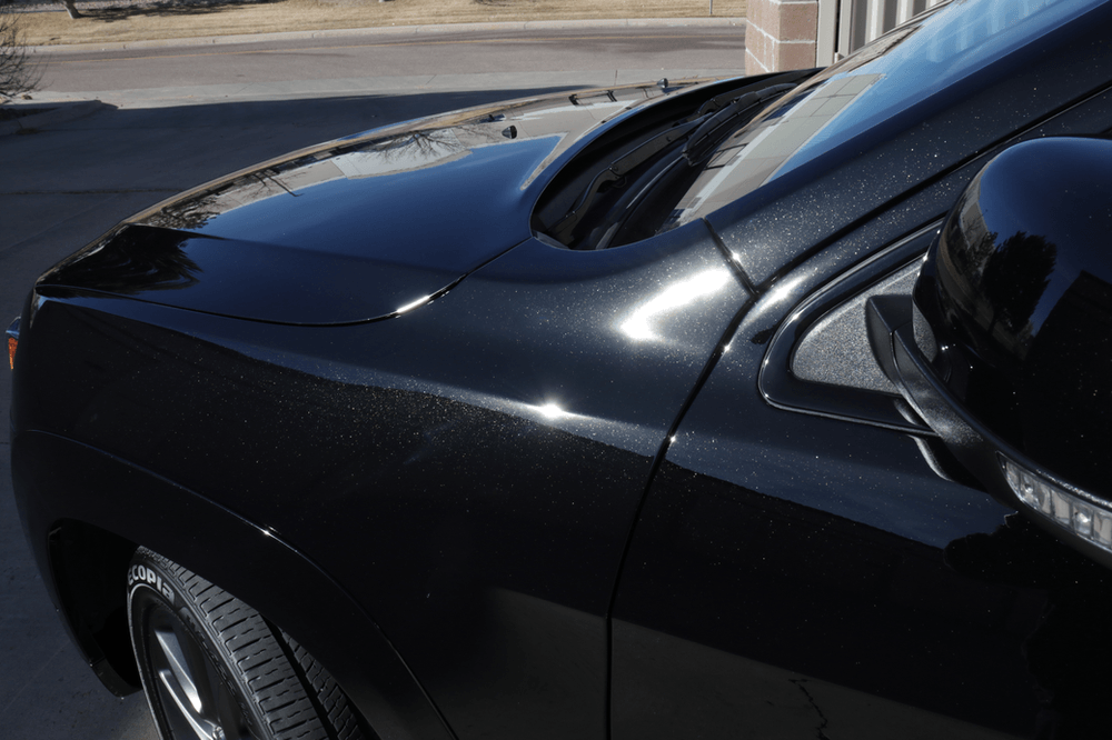 A black car is parked on the side of the road