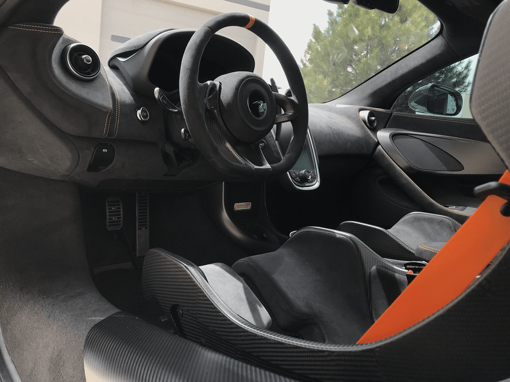 The inside of a car with a steering wheel and seat