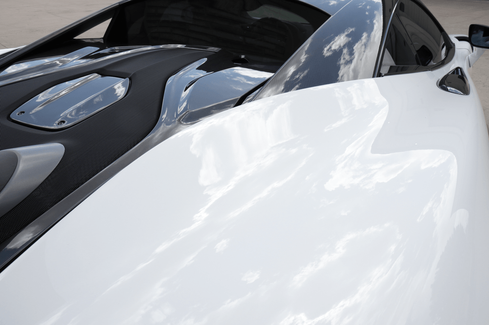 A close up of the hood of a white sports car