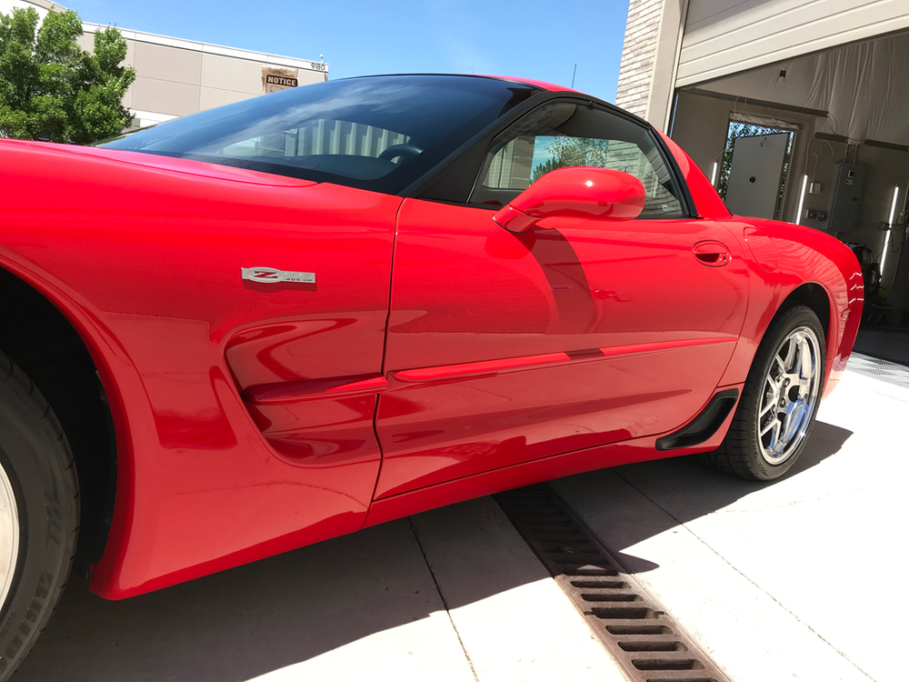A red sports car is parked in a parking lot.