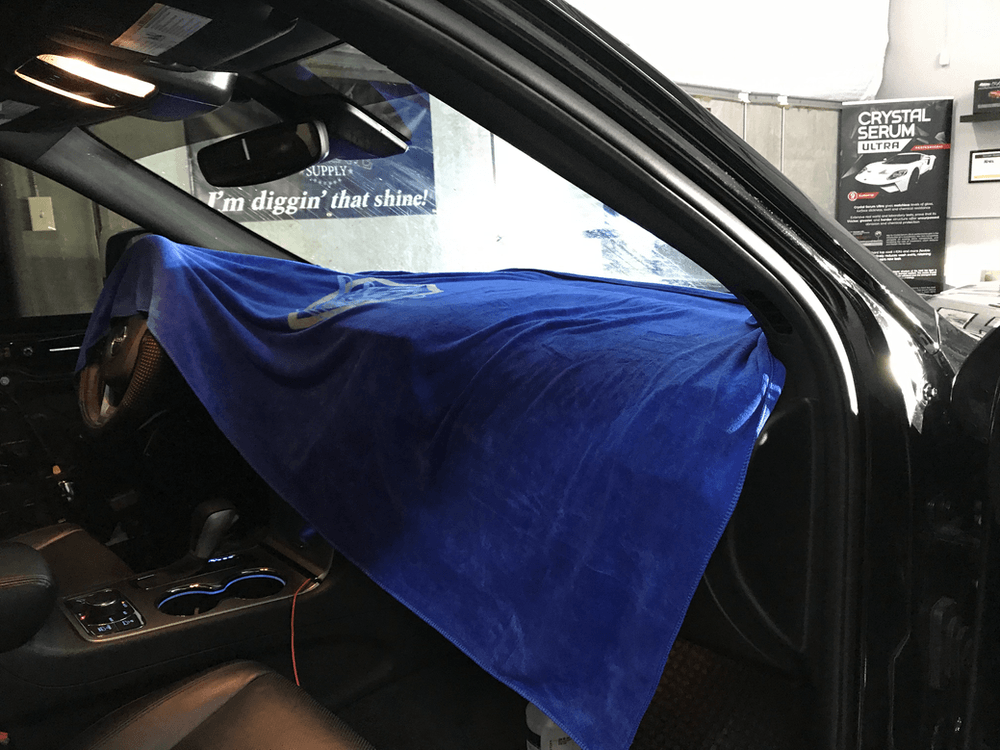 A black car with a blue cloth covering the dashboard