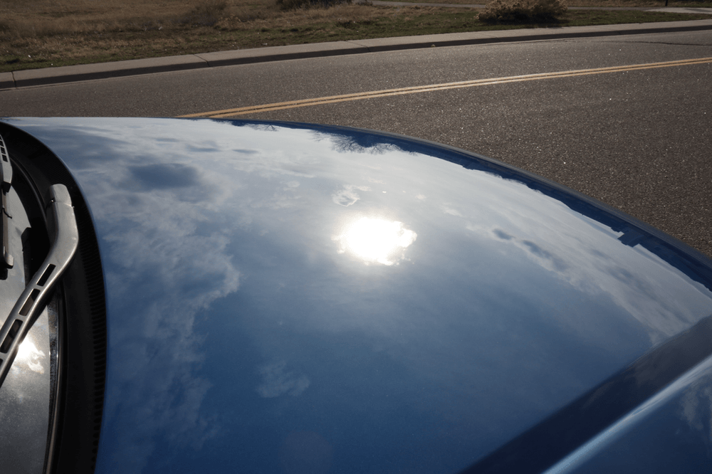 A blue car is parked on the side of the road
