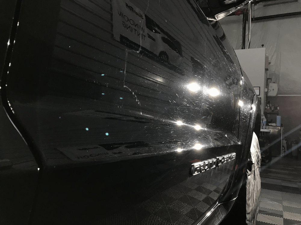 A close up of a black car in a garage