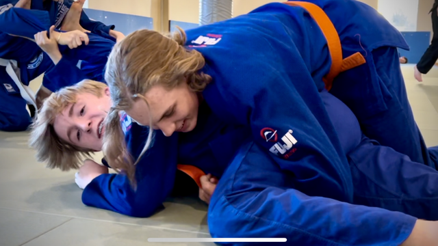 A group of people are practicing judo on a mat.