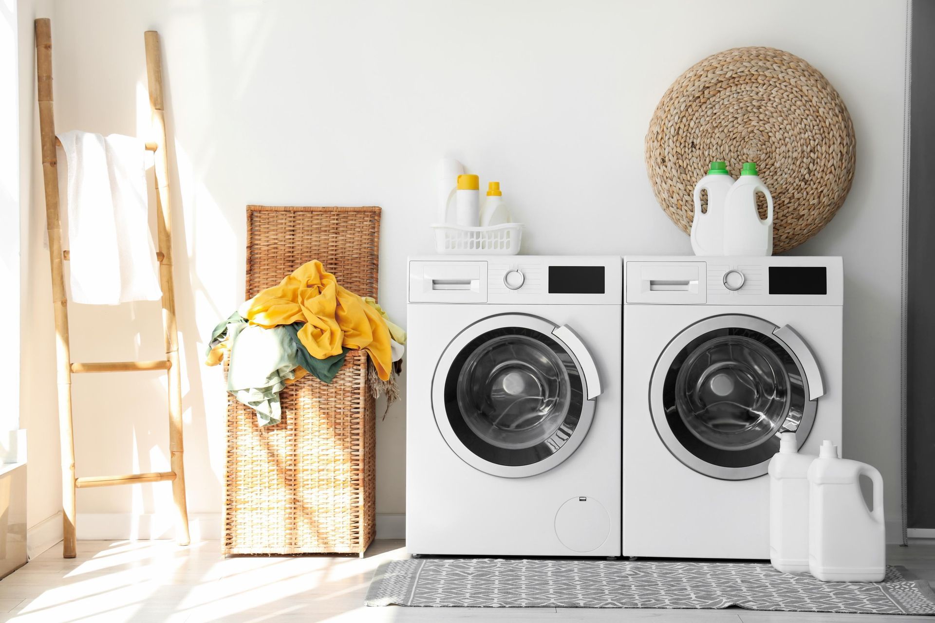 two washing machines are sitting next to each other in a laundry room