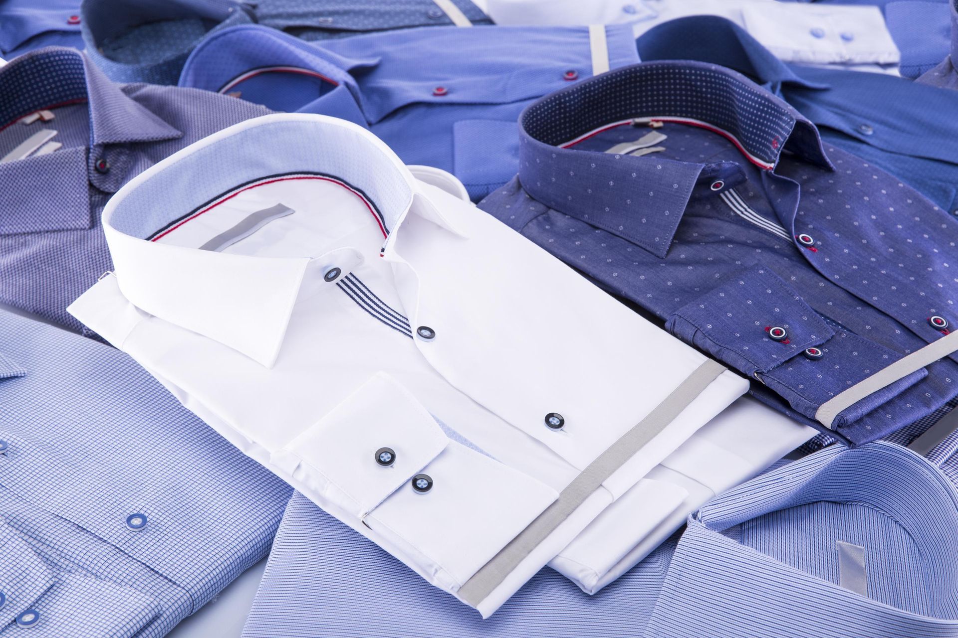 a bunch of shirts are stacked on top of each other on a table
