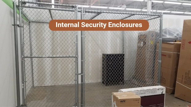 A metal chain link cage with a door inside a store. Boxes and a black container sit within the cage.