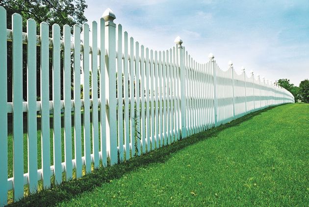 White picket fence on green lawn.