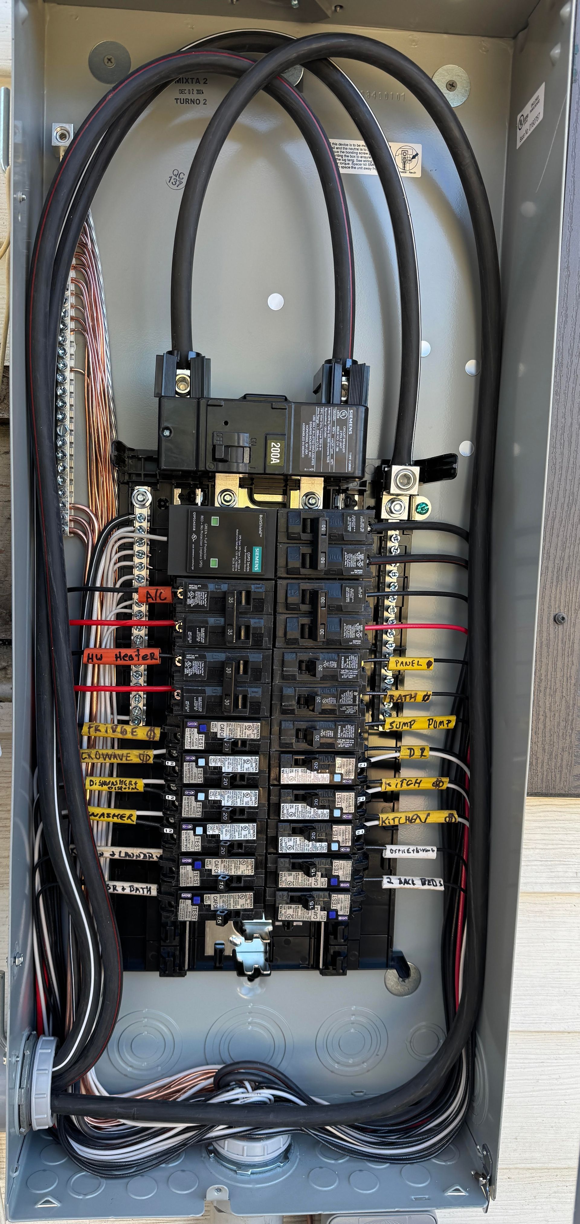Electrical panel with circuit breakers and wires.