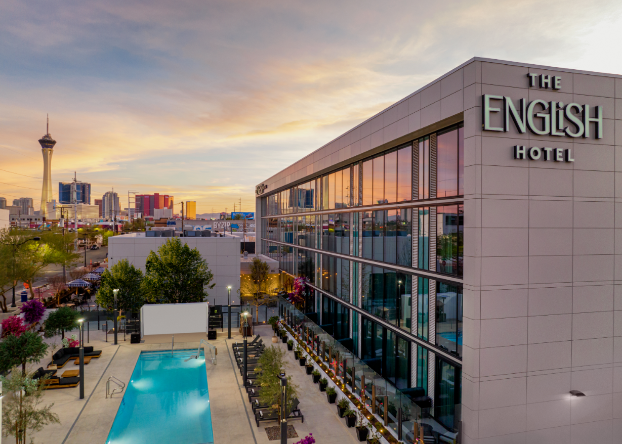 An aerial view of the english hotel with a swimming pool in front of it.
