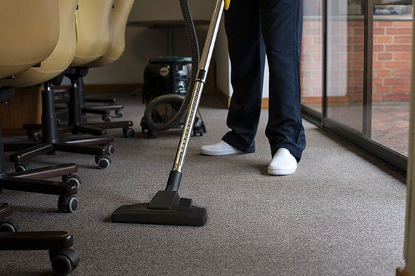 Man Vacuuming the Carpet of an Office — Fort Collins, CO — Aspen Enterprises of North Colorado Man Vacuuming the Carpet of an Office — Fort Collins, CO — Aspen Enterprises of North Colorado