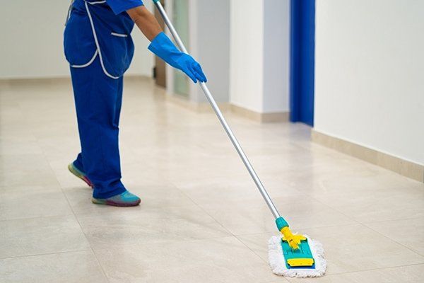 Cleaning Lady Cleans the Hallway with a Mop — Fort Collins, CO — Aspen Enterprises of North Colorado Cleaning Lady Cleans the Hallway with a Mop — Fort Collins, CO — Aspen Enterprises of North Colorado
