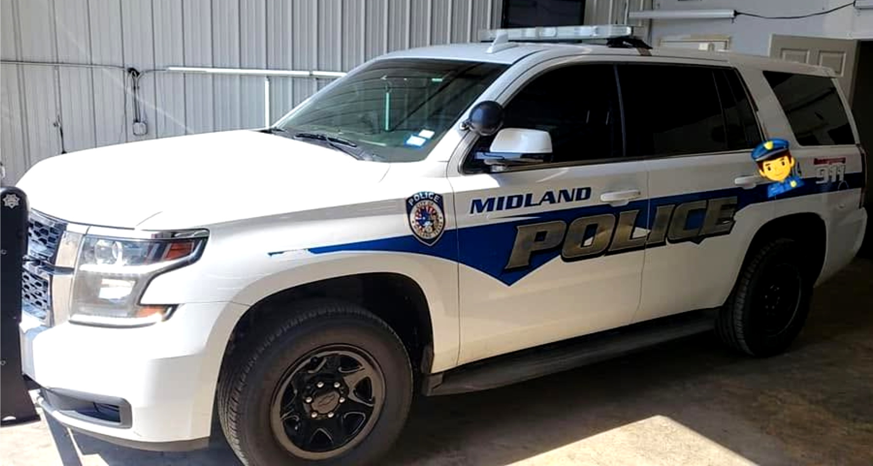 Midland police SUV parked outdoors, white with blue lettering and black push bumper