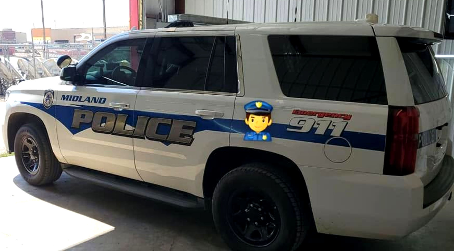 White police SUV parked in a garage, with blue-and-gold “POLICE” markings on the side.