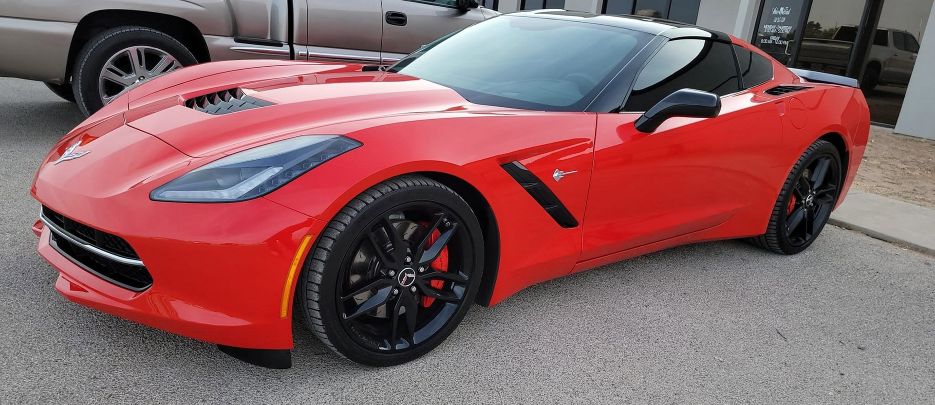 Red sports convertible parked outdoors, shown in front-left view.
