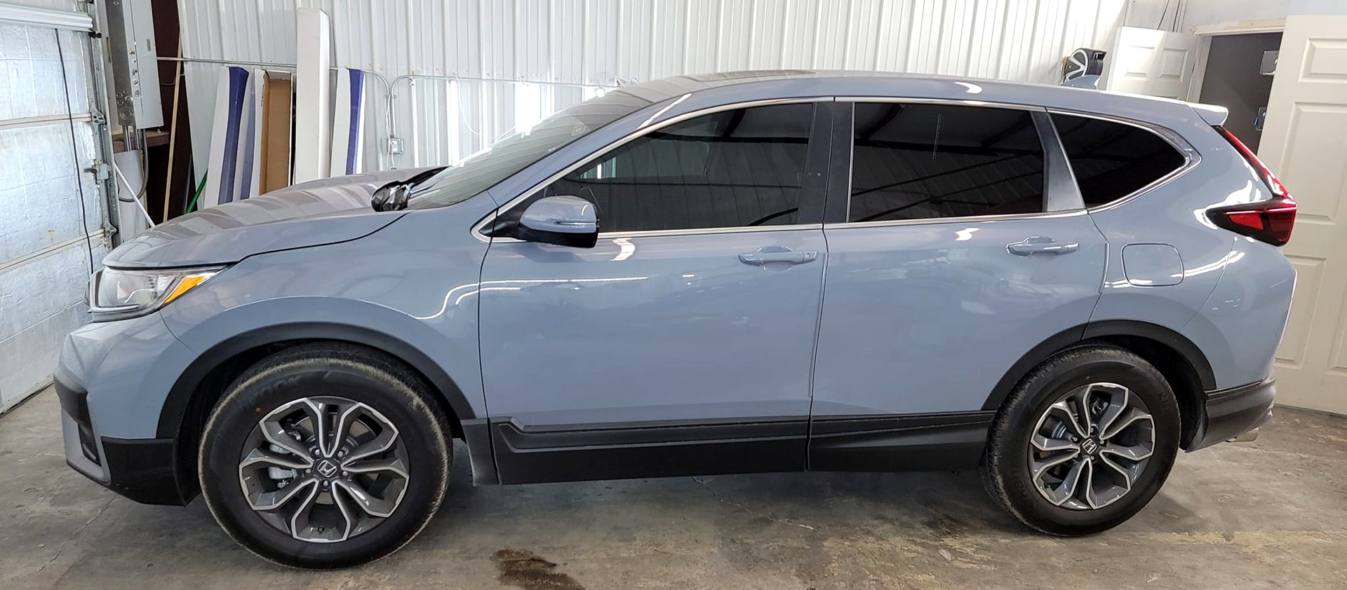Gray SUV parked indoors in a garage, side view.