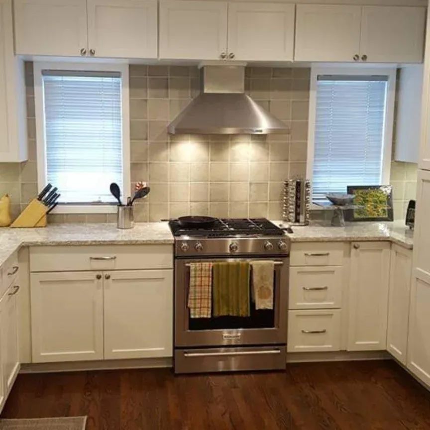 A kitchen with stainless steel appliances and white cabinets