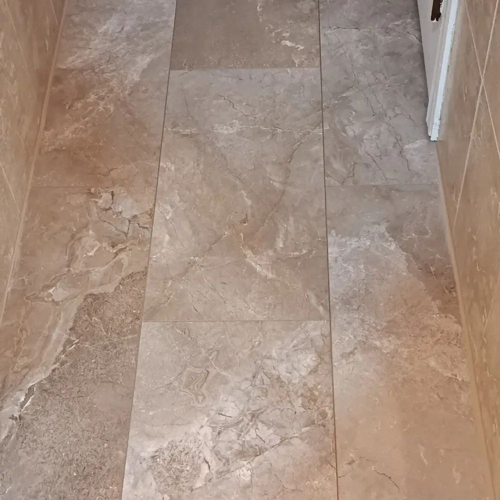 A tiled floor in a hallway with a door in the background