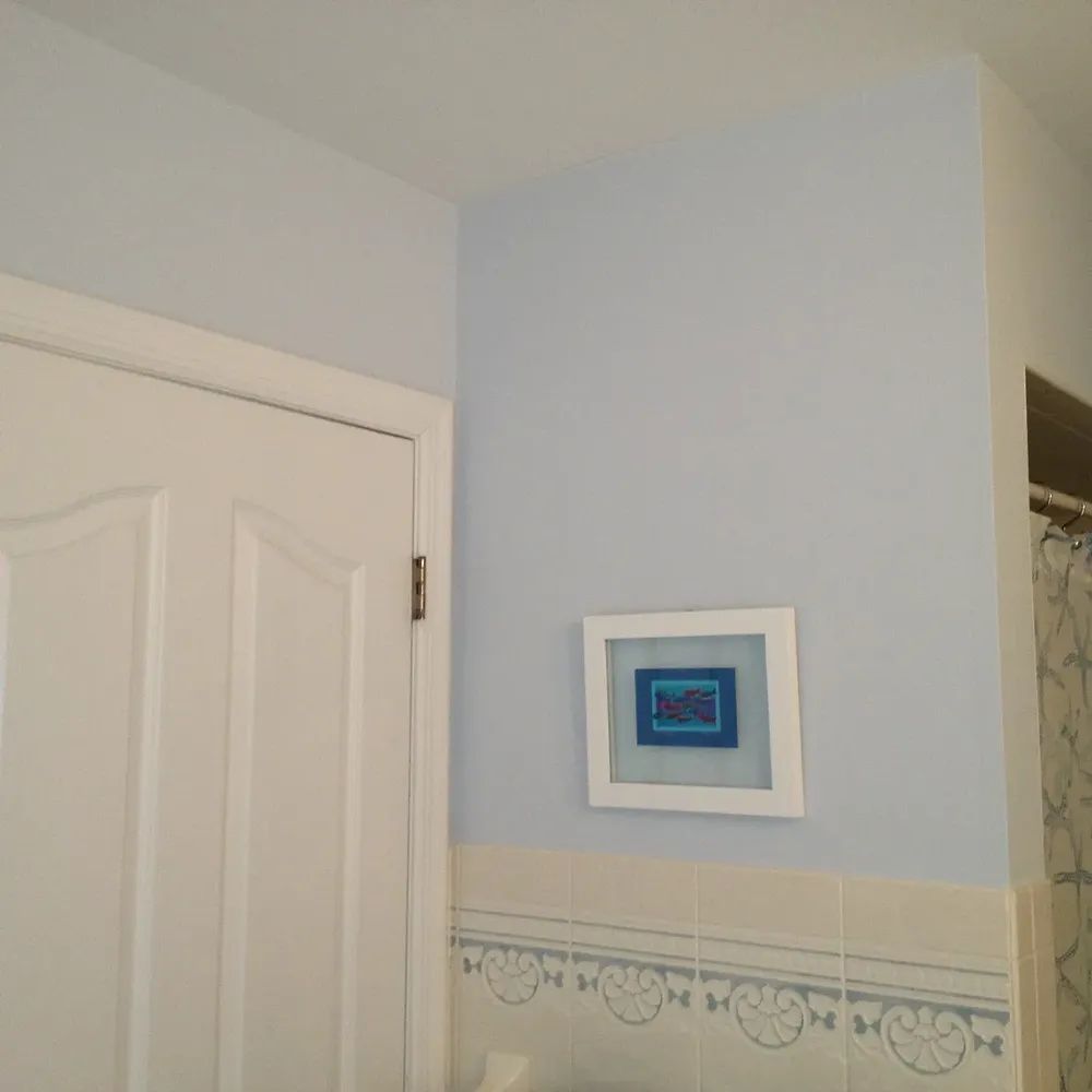 A bathroom with a picture on the wall that says love