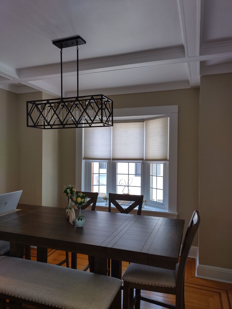 A dining room with a table and chairs and a chandelier hanging from the ceiling