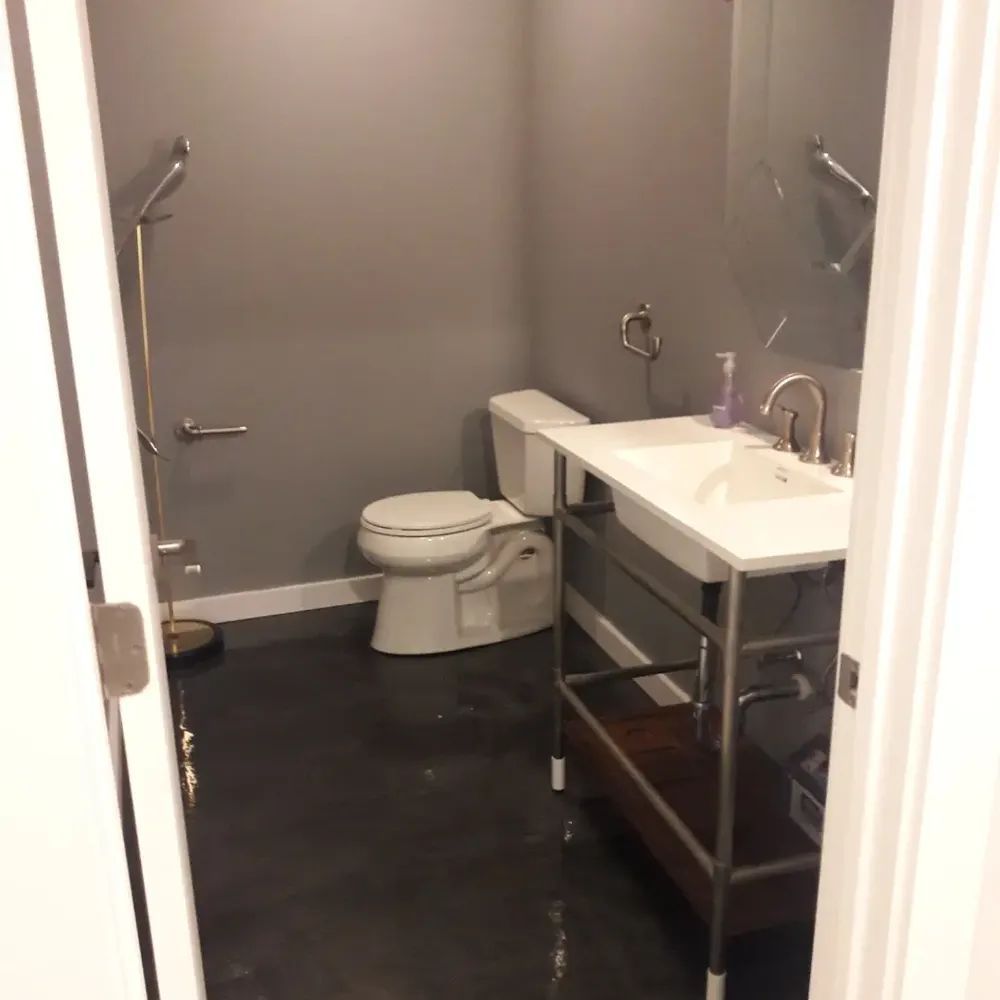 A bathroom with a toilet a sink and a mirror