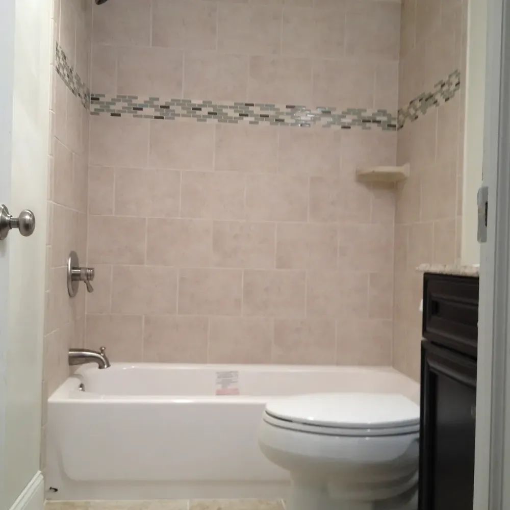 A bathroom with a tub , toilet and sink.