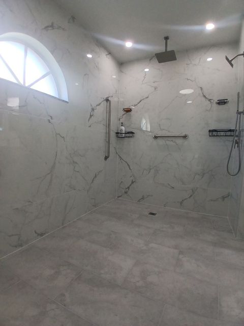 A bathroom with a walk in shower and a window