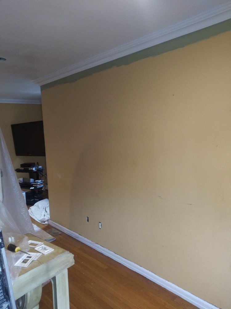 A living room with a large wall and a wooden floor.