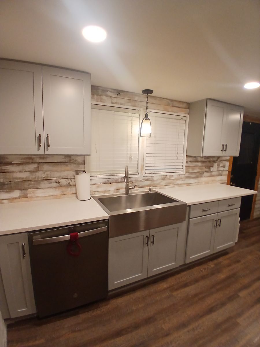 A kitchen with white cabinets and a stainless steel sink