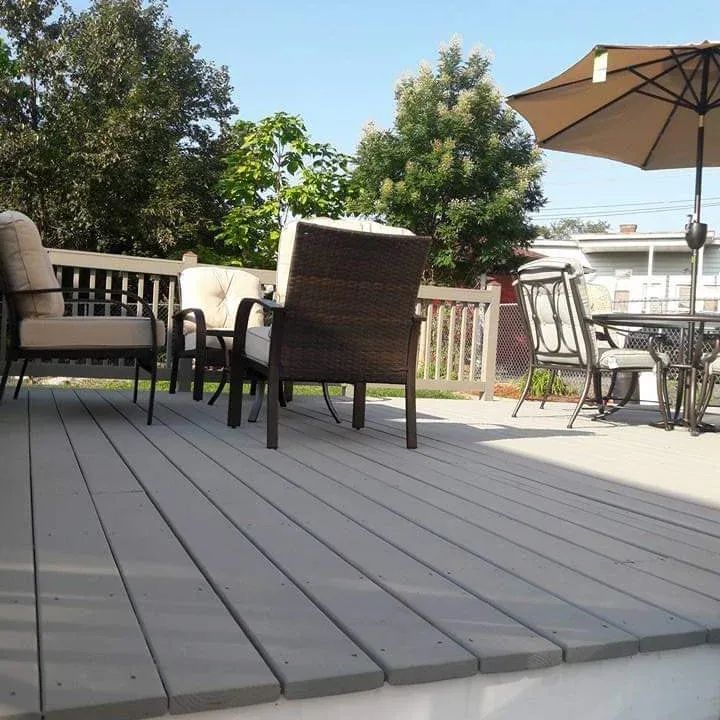 A deck with a table and chairs and an umbrella