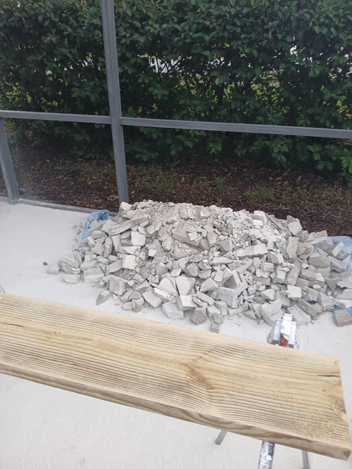 A pile of bricks is sitting on the ground next to a wooden plank