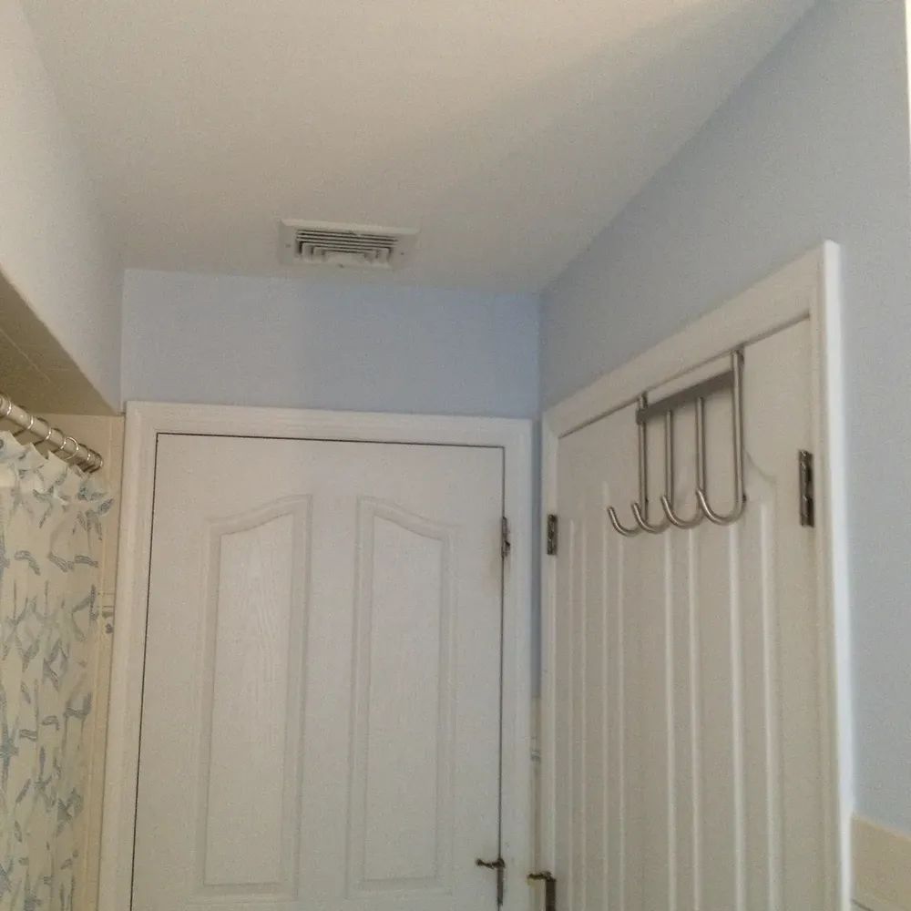 A bathroom with white doors and a shower curtain