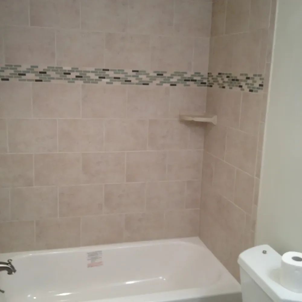A bathtub in a bathroom next to a toilet