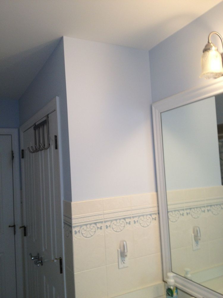 A bathroom with a mirror and a light on the wall