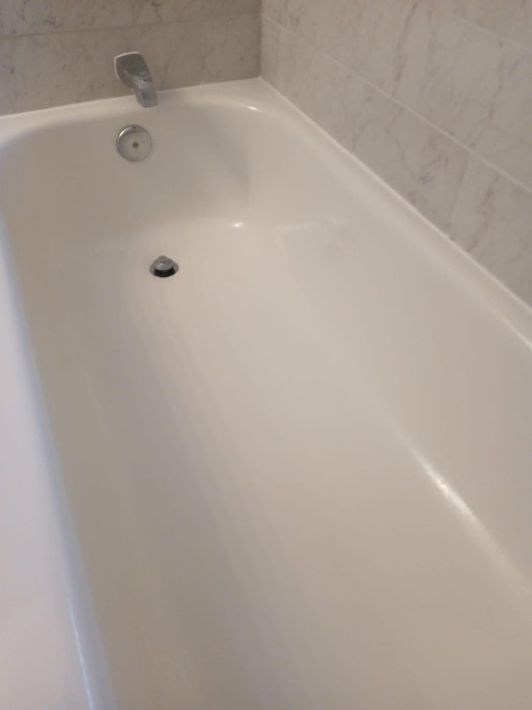A white bathtub is sitting in a bathroom next to a tiled wall