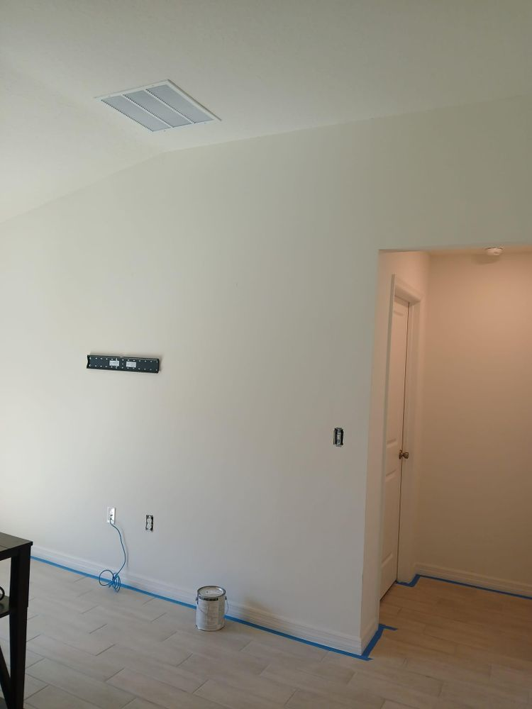 A living room with white walls and a blue tape on the floor